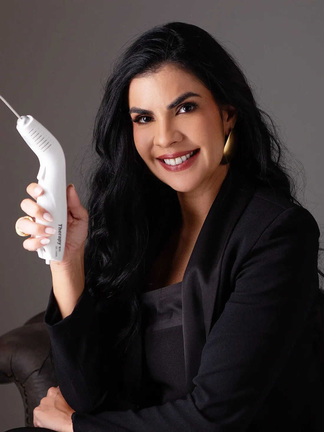 Dra. Juliana Borges segurando uma caneta de laser terapêutico